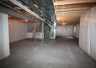 Unfinished basement in a new home in Omaha with ductwork connecting to furnace.