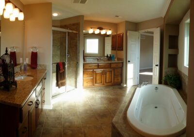 Master bathroom with whirlpool bath tub and clear glass shower by a home builder in Omaha, NE.