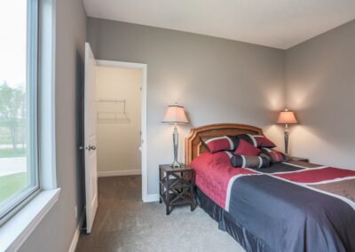 Furnished bedroom w/ walk-in closet & grey tone coloring