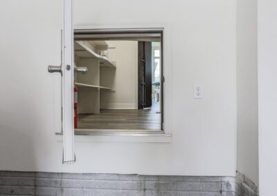 Small white door connecting garage to pantry. Patent Pending - Aurora Homes Omaha NE.