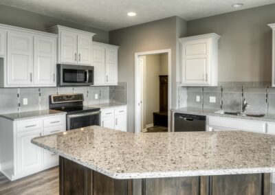 Modern Kitchen with white cabinets, stained island, and stainless steel appliances in Papillion, NE.