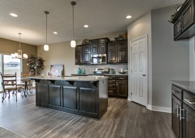 Large kitchen & dinette with dark cabinets by Aurora Homes Omaha