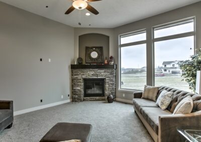 Gas fireplace near huge windows in Omaha by Aurora Homes.