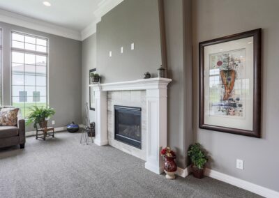 Fireplace w/ white mantel by Omaha new home builder