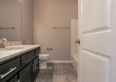 Main Bathroom with black vanity and granite countertop.