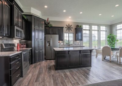 Trendy Home Kitchen w/ hidden pantry, big island, & lofty ceiling