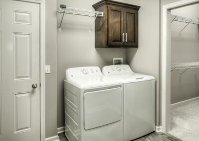 Laundry room with extra storage closet by an Omaha Home Builder.