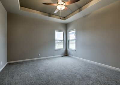 Primary bedroom with raised ceiling and fan in Papillion, NE.