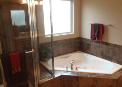Whirlpool tub with large privacy window and glass shower.