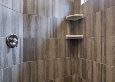 Walk in shower with grey stripe tile.