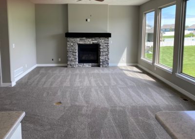 Family room with gas fireplace and beautiful back yard on a bright day