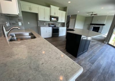 Granite countertops with white painted cabinets and black stained kitchen island.