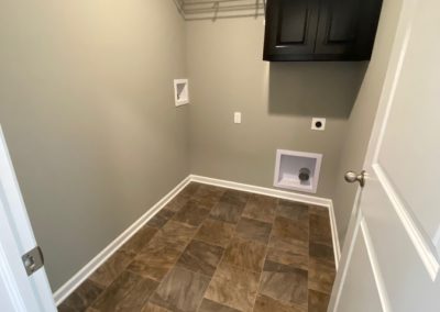 Laundry Room with stained storage cabinet and earth tone flooring
