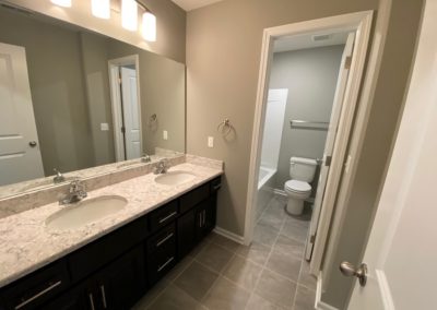 Main bathroom with two sinks and separate stool/tub room in Omaha.