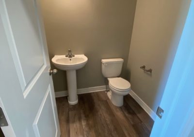 Powder bathroom with white pedestal sink and toilet