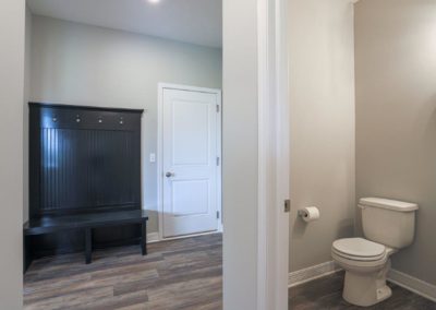Mud room and powder bath with LVP flooring by Aurora Homes Omaha, NE