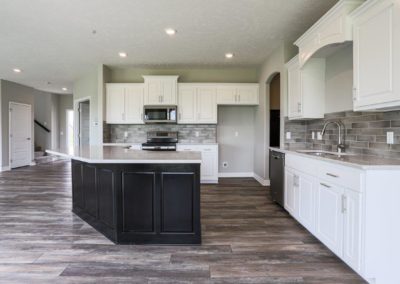 Kitchen with white cabinets and gigantic birch island that is stained black.