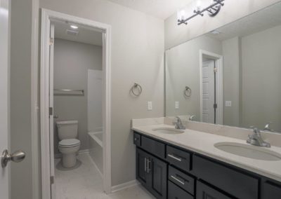 Bathroom with 2 sinks and separate room for toilet and shower tub.