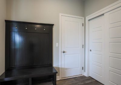 Mud Room with white woodwork and black bench coat rack.