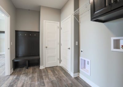 Mud Room / Laundry with bench seat and storage by Aurora Homes.