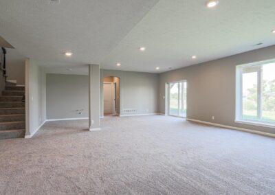 Basement Flex Space by Aurora Homes with large windows.
