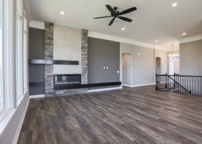 Large family room with elegant stone and tile accents around an electric fireplace.