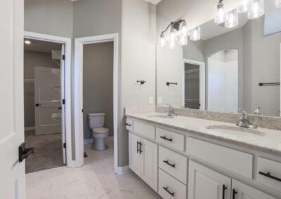 Bathroom vanity with 2 sinks, white cabinets, and quartz countertop in Omaha, NE.