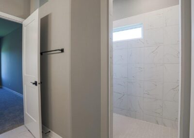 Walk-in Shower with rain-glass window and white tile.