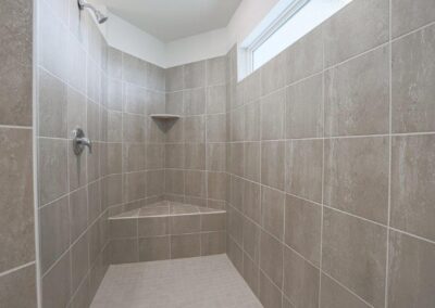 walk in tile shower with bench seat by Aurora Homes in Omaha