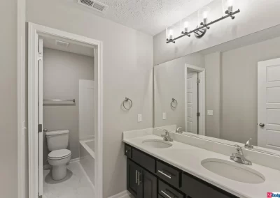 bathroom with dual vanity and stool area