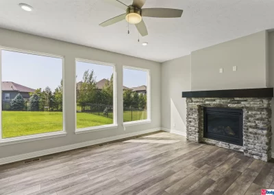 family room with large windows and gas fireplace by Aurora Homes